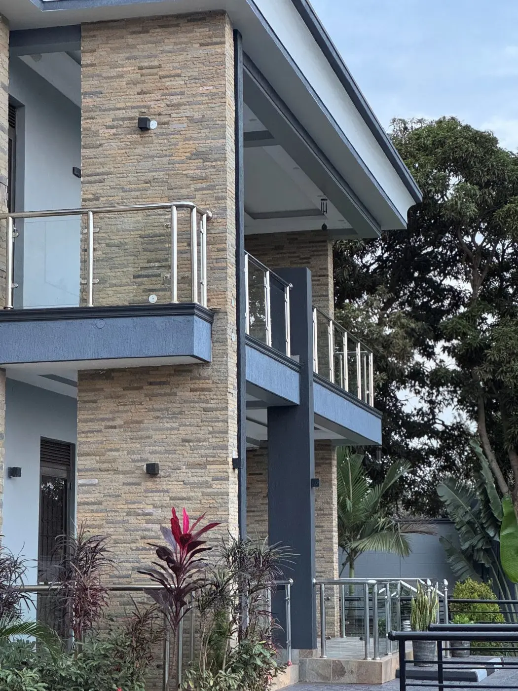 Finished house front, Home remodel, fountain and landscaping, Jinja